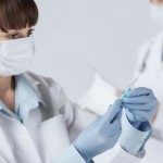 female doctor holding syringe with injection